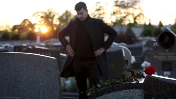 Trieste Man Staat Voor Een Graf Bij Zonsondergang Beelden — Stockvideo