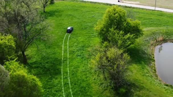 Автомобиль Едет Зеленому Полю Оставляя Дороге Следы Шин Воздушный Отвод — стоковое видео