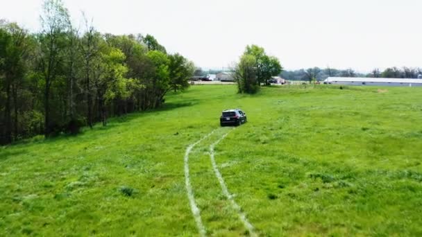 プロパティの監視中に緑のメドウズで運転車の後シロアム春の近く アーカンソー州 空中射撃 — ストック動画