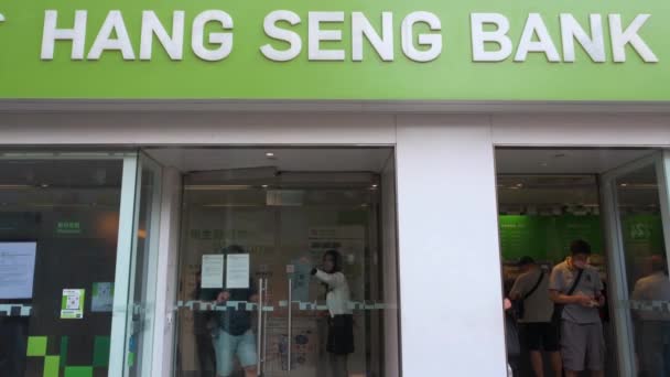 歩行者は香港を拠点とする銀行 金融サービス会社と香港株式市場の一次指標 ハンセン銀行 香港支店を通ります — ストック動画