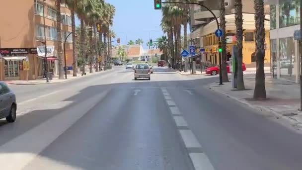从公共汽车的前窗眺望马拉加的街道 路边的棕榈树 街上的红绿灯从马拉加市中心开车出去海滩上的白宫 — 图库视频影像