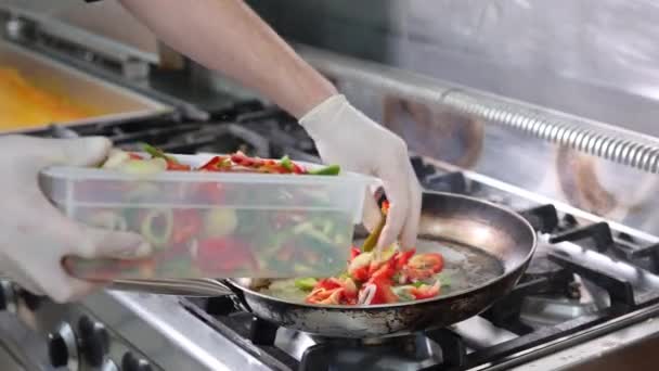 シェフが野菜をフライパンに入れ 4K映像 — ストック動画