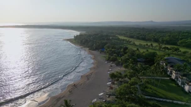 在Playa Dorada海滩上空拍摄 日落时在水面和森林景观上反射阳光 多米尼加共和国普拉塔港 — 图库视频影像