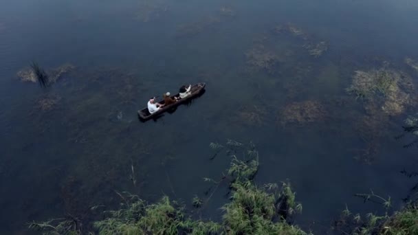 三个穿着中世纪服装的男人在湖面的木船上划船 — 图库视频影像