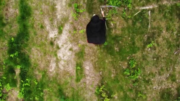 Vista Superior Muerte Parca Con Guadaña Caminando Naturaleza Seguimiento Aéreo — Vídeo de stock