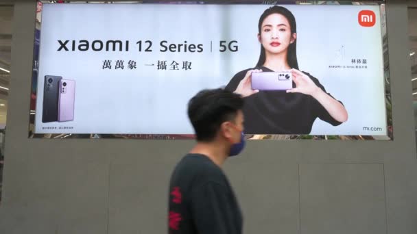 Xiaomi Kínai Tech Márka Kereskedelmi Hirdetése Mellett Elhaladó Gyalogosok Okostelefont — Stock videók