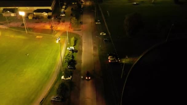 夜間に野球場を出る車の空中がライトアップ — ストック動画