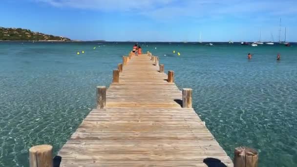 在法国科西嘉岛的圣朱利亚海滩 人们在木制码头上沐浴 用地中海的碧绿水晶水沐浴 50英尺每秒的假日概念镜头 — 图库视频影像