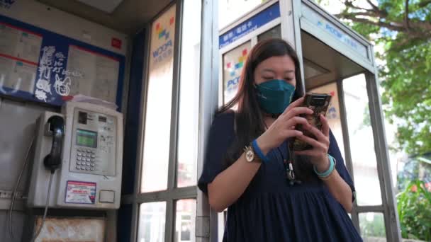 Низькокутний Вид Жінку Використовує Смартфон Поруч Громадськими Телефонними Будками Які — стокове відео