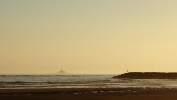 日落时在防波堤上钓鱼的孤独渔民的轮廓 拍摄得很宽 — 图库视频影像