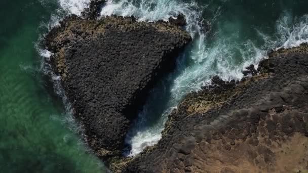 火山岩の形成のユニークな眺めは 波を破ることによって囲まれた自然な原因の道を作り出します ドローンビュー — ストック動画