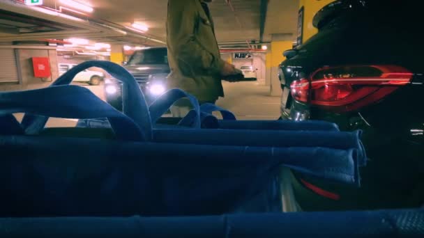 Opening Kofferbak Nachts Ondergrondse Parkeergarage Buurt Van Winkelwagen Tassen — Stockvideo