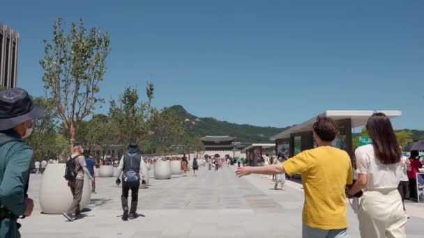 ソウルのダウンタウンにある光化門広場を改装して顔の面を歩くシニア韓国人旅行者 コピースペース 撮影を確立 — ストック動画