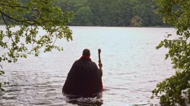 Mann Mit Schwarzem Mantel Und Sense Stürzt Sich Ins Wasser — Stockvideo