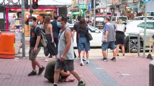 当行人走过香港街道时 一个女人把钱放进乞丐的杯子里 — 图库视频影像