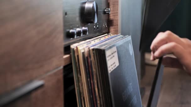 在家里的收藏品里放回一张乙烯唱片 Dj单曲或专辑 选择高质量的音乐在转盘上听 后面的扩音器男人的手的特写 慢动作 — 图库视频影像