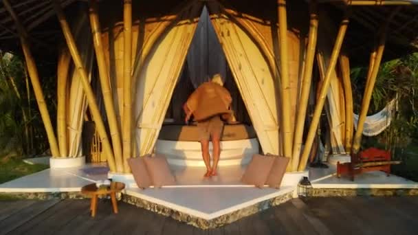 Молодой Человек Веселится Большой Шляпе Сексуальная Подружка Отдыхает Гамаке Бамбуковой — стоковое видео