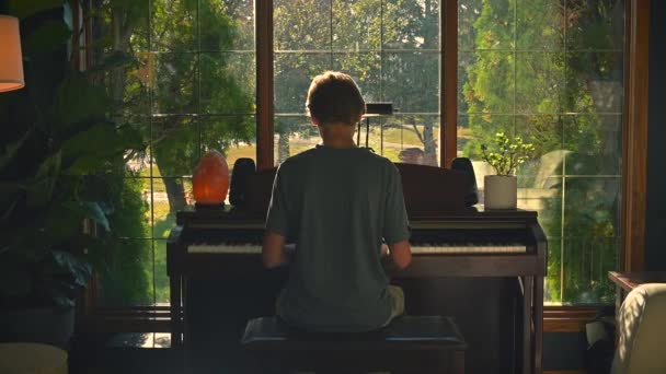 Niño Tocando Piano Por Una Ventana Tiro Ancho — Vídeos de Stock