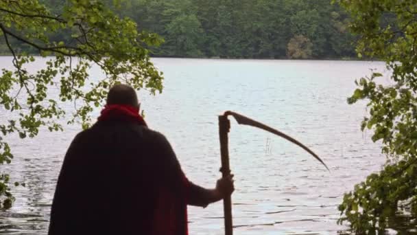 Grim Reaper Black Cloak Scythe Walks Water Lake Static View — Stock Video