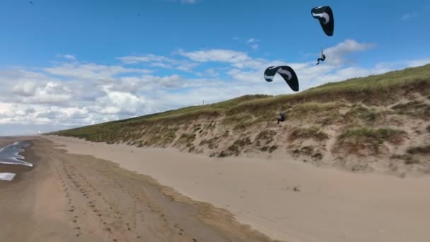 ภาพการต ดตามภาพยนตร แสดงค ของ Paraglider เหน อชายหาดและชายฝ งของประเทศเนเธอร แลนด โอก — วีดีโอสต็อก