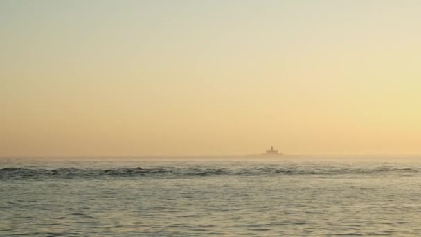 日落时从大海中央的一艘船看到一座灯塔 — 图库视频影像