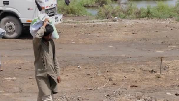 Pakistani Male Carrying Aid Sack Shoulder Flood Relief Camp Slow — Stock Video