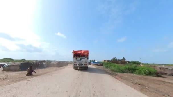 シンド洪水救援キャンプへの援助トラックに続く道路に沿ってPov乗馬 — ストック動画