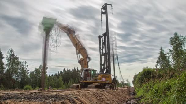 ラトビアのリガ近郊の森を通る道路を建設する重機の乗組員 時間経過 — ストック動画
