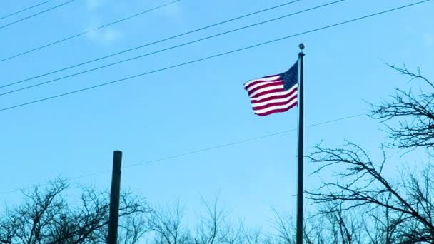 在一个无云的下午 美国国旗挂在一根杆子上 背后是蓝天 — 图库视频影像