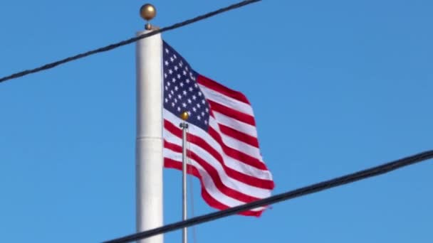 Amerikaanse Vlag Tussen Twee Elektriciteitsleidingen Een Grote Paal Zwaaiend Tijdens — Stockvideo