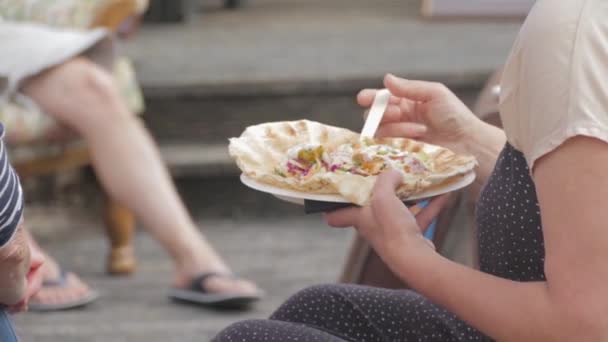 Kvinna Äter Och Njuter Smaklig Tunnbröd Utanför Samtal Party Festival — Stockvideo