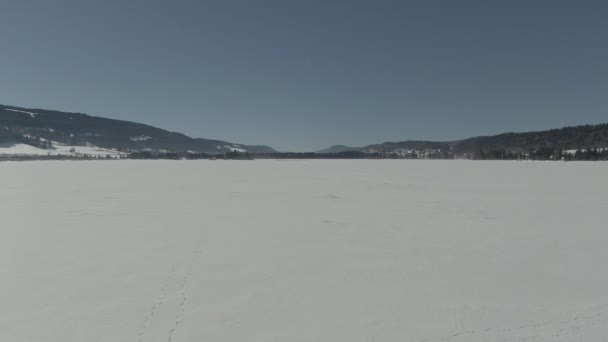 Drone Buzda Yürüyen Bir Çiftin Üzerinde Uçarken Donmuş Bir Gölün — Stok video
