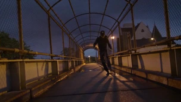 アフリカ系アメリカ人の男性が雨の夜に橋の上で踊る — ストック動画