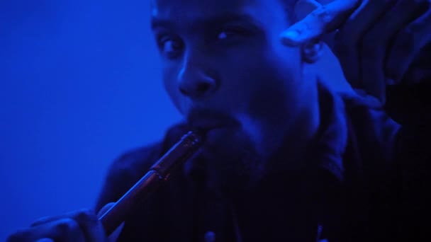 Afroamerikaner Pustet Rauch Aus Einer Wasserpfeife Einem Blau Beleuchteten Raum — Stockvideo