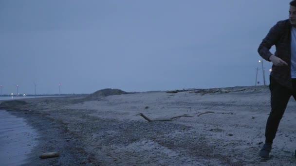冷たい湖で岩をスキップ白人男性 — ストック動画