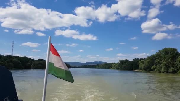 화창한 여름날 헝가리 국기에 푹신한 구름이 강에서 보트를 — 비디오
