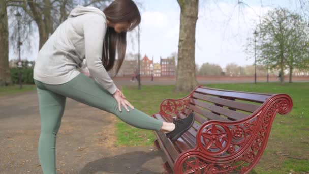 Žena Běžec Protáhnout Nohu Lavičce Parku Před Spuštěním — Stock video