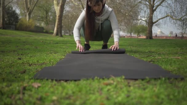 Beyaz Kadın Yoga Minderini Parka Yuvarlıyor — Stok video