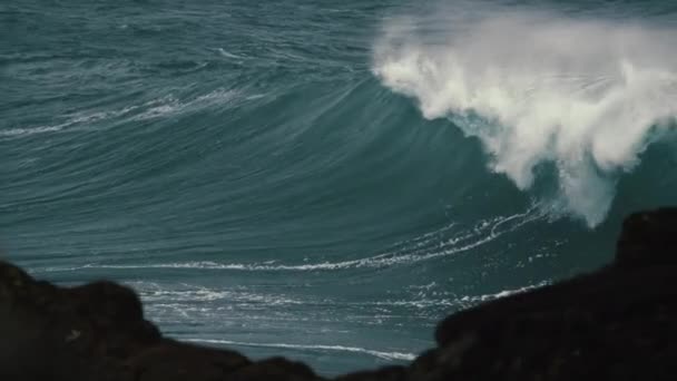 ゆっくりとした動きの中で大きく重い波が砕けていく岩を見ると — ストック動画