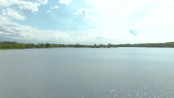 イリノイ州レモント近くのシカゴの西部郊外にある小さな郊外の国立公園の湖で水の上に垂直方向のパンニング運動で高速移動ショット タンピア スロー湖 — ストック動画
