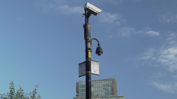背景に移動雲と2つのCctvの警告標識を持つ2台のCctvカメラ — ストック動画