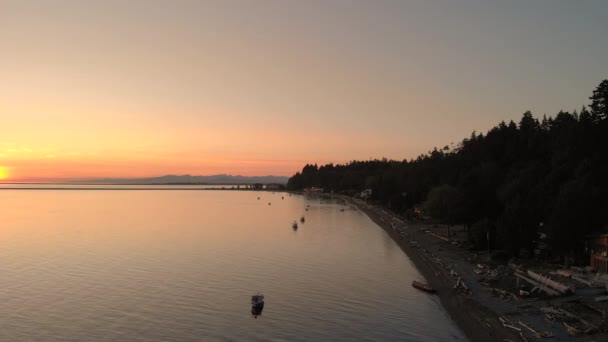夕日の前にある海岸線 ビーチ 駐車場のボートを空中で明らかにしました — ストック動画
