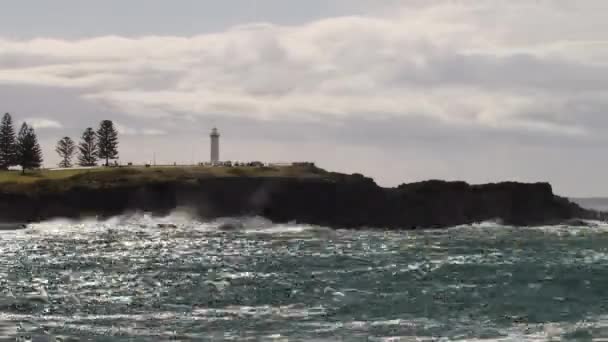 海が下の岩の周りを洗うとき 雲が空を通過する灯台の時間経過 — ストック動画