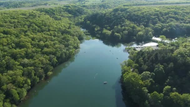 Aerial Nad Spokojnym Ciemnozielonym Jeziorem Górskim Odzwierciedlającym Słońce Kilkoma Łodziami — Wideo stockowe