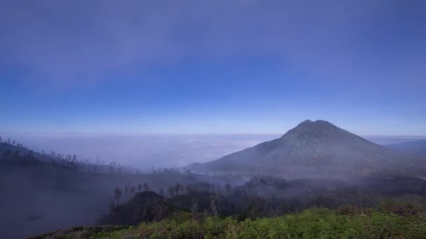 東ジャワ州モント イジェンの火山の風景と雲の下に転がり落ちる霧 — ストック動画