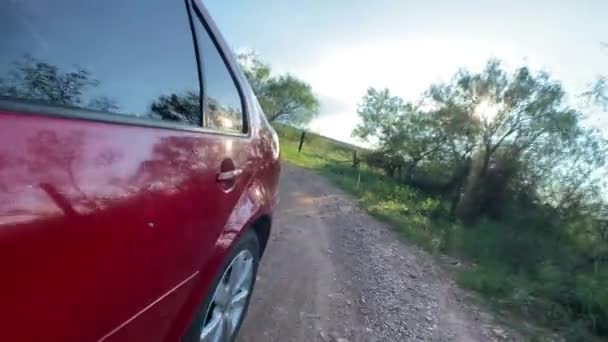 Червоний Автомобіль Їде Брудній Дорозі Сонцем Сяє Позаду — стокове відео