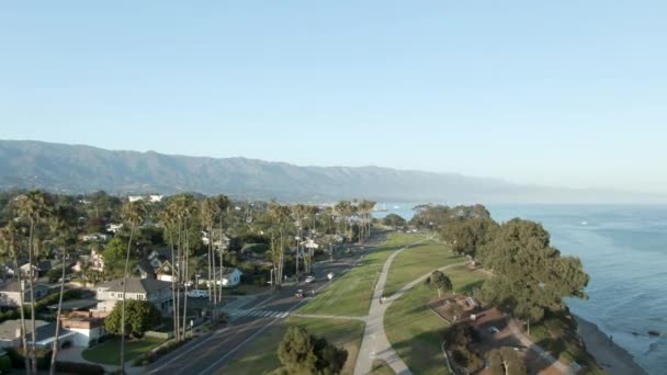 从海岸公园可以看到 日落时加利福尼亚圣巴巴拉的空中上升 斯泰恩码头的水面上和市中心都可以看到船 人们在公园里散步 — 图库视频影像