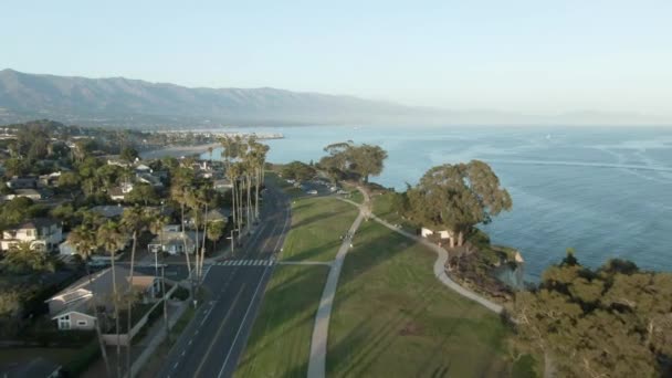 美国加利福尼亚州圣巴巴拉市 在日落时分 高空空中飞越了以树木为背景的海岸城市公园和以山脉为背景的太平洋 公园是海岸公园 — 图库视频影像