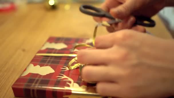 Fazendo Arco Com Tesoura Fita Fina Ouro Envolvendo Presente Natal — Vídeo de Stock