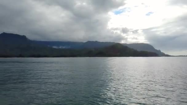 Hawaii Kauai バックライト付きの山々から海岸線沿いの山々にパンを左に海にボート — ストック動画